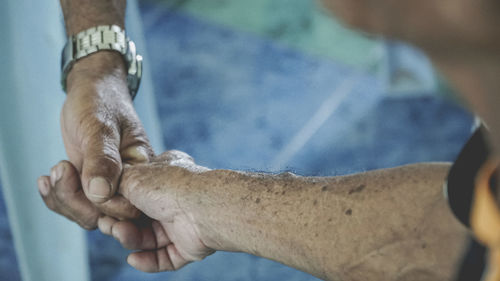 Cropped image of men holding friend hand