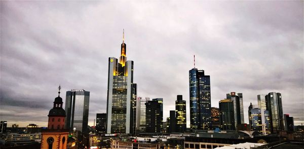 Modern cityscape against cloudy sky