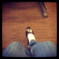 Low section of woman standing on wooden floor