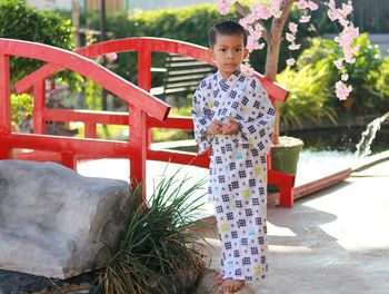 Asian boy wearing uniform japan background bamboo fence mountain view  light sunlight nature evening