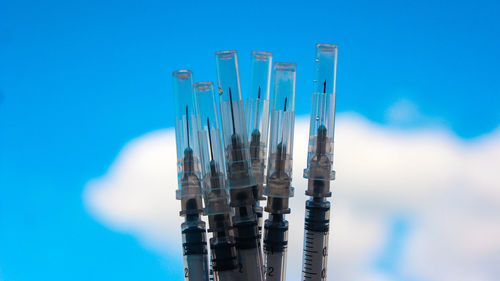 Low angle view of glass against blue sky