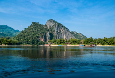 Scenic view of sea and mountains against sky