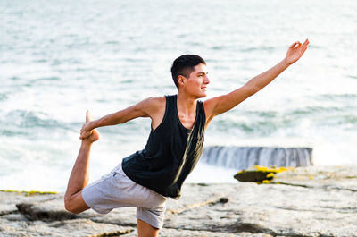 Man doing yoga at beach