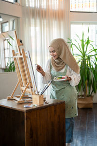 Young woman using laptop while sitting on table