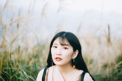 Portrait of beautiful young woman on field