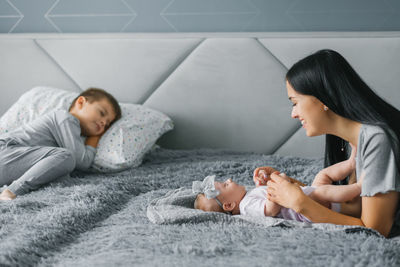 Mom looks at her newborn daughter, who lies on the body. family happy with new family member