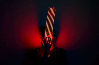 Close-up of person playing guitar against black background