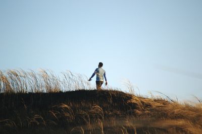 Man standing on field against clear sky