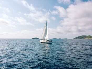 Sailboat sailing on sea against sky