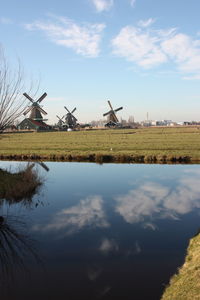 Traditional windmill on field against sky