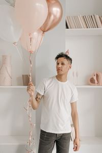 Portrait of young man holding balloons