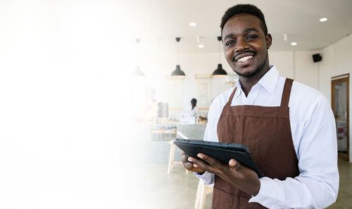 Portrait of a smiling young man holding smart phone