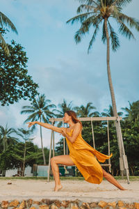 Woman with palm trees against sky