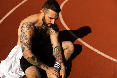 Low angle view of young man sitting on floor