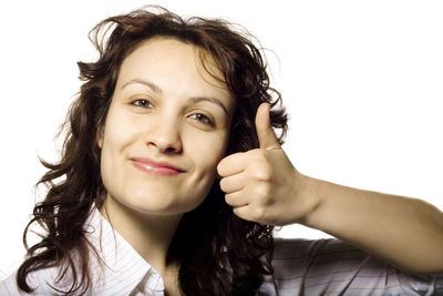 Close-up portrait of a smiling young woman over white background