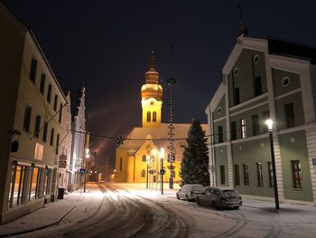 Illuminated street in city at night