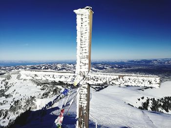 Scenic view of snow covered mountain against blue sky