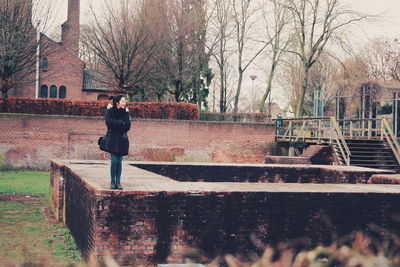 Full length of man standing on bare tree