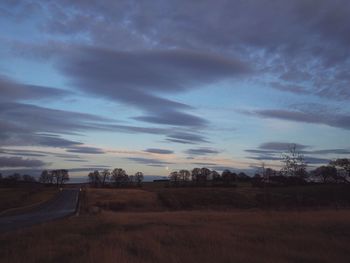 Scenic view of agricultural field against dramatic sky