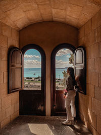 Rear view of woman walking in tunnel