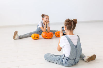 Sister photographing girl at home