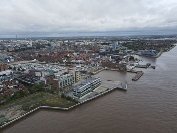 High angle view of buildings by sea against sky