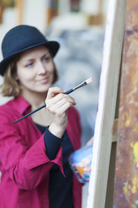 Portrait of smiling woman holding hat