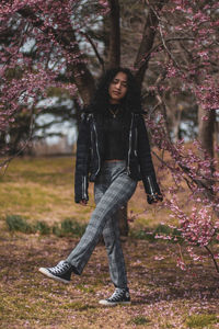 Portrait of young woman standing by tree