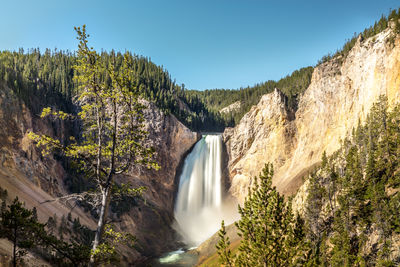 Scenic view of waterfall against sky