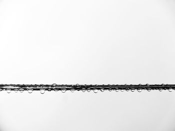 Low angle view of power lines against clear sky