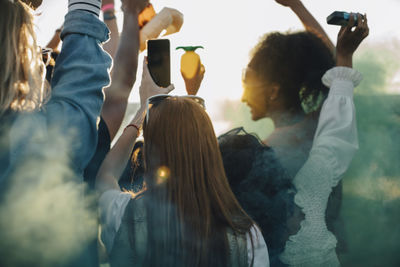 Rear view of friends dancing together in music festival