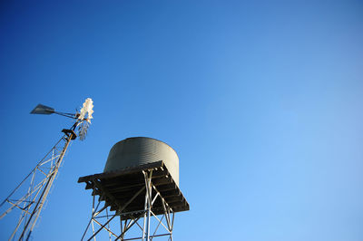 Low angle view of communications tower against clear blue sky