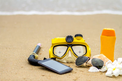 Close-up of eyeglasses on sand at beach