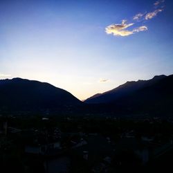 Silhouette town against sky during sunset