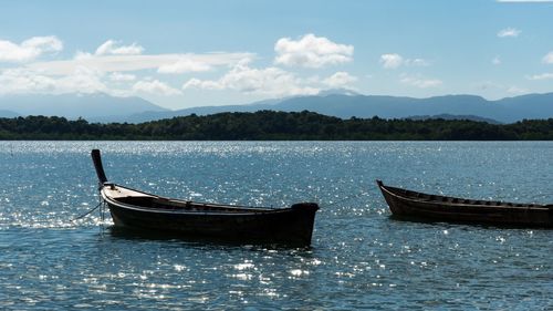 Boat moored in lake against sky