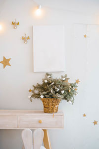 Composition of christmas tree branches with toys on them in a wicker basket in the decor 