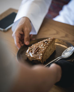 Close-up of hand holding ice cream on table