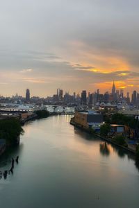 View of buildings at waterfront during sunset