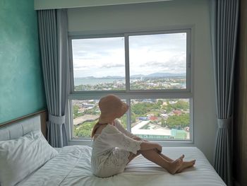 Woman sitting on bed at home