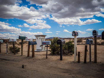 Mailboxes against cloudy sky