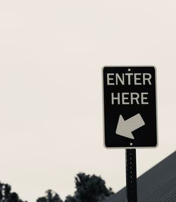 Close-up of road sign against clear sky