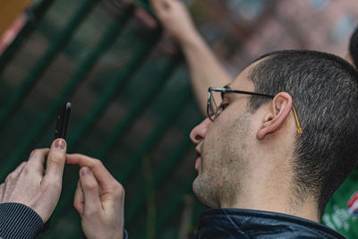 Close-up portrait of young man using mobile phone