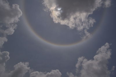 Low angle view of rainbow against cloudy sky