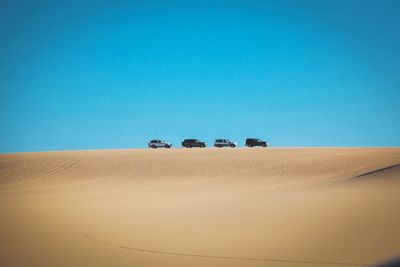 Scenic view of desert against clear blue sky