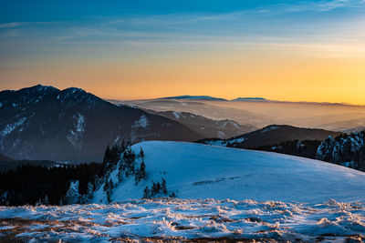 Scenic view of snowcapped mountains against sky during sunset