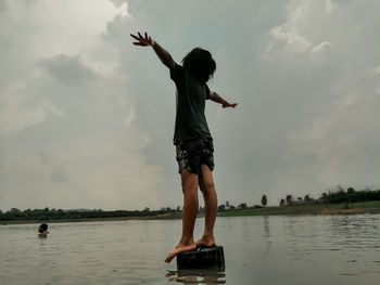 Full length of woman standing in water against sky