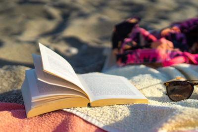 Close-up of open book on beach