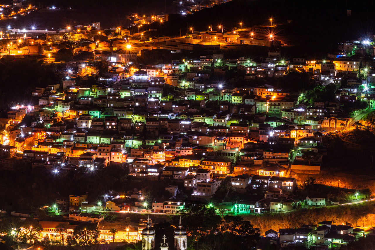HIGH ANGLE VIEW OF ILLUMINATED CITY BUILDINGS AT NIGHT