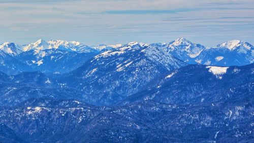 Scenic view of snowcapped mountains against blue sky