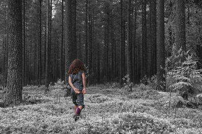 Full length rear view of girl walking in forest